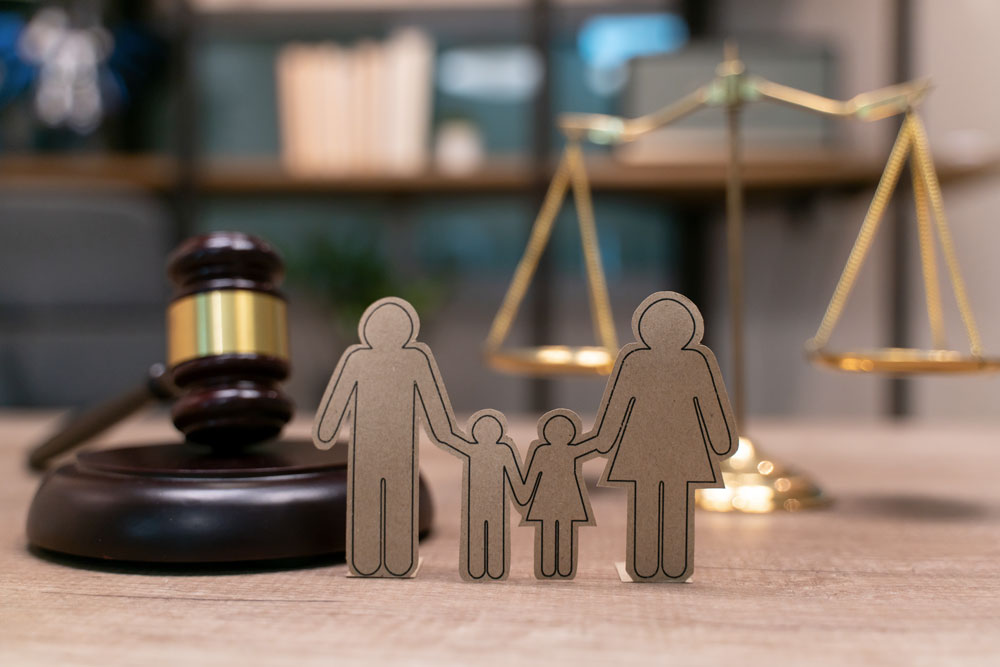 En utklippt familj i kartong framför en domstolsklubba
